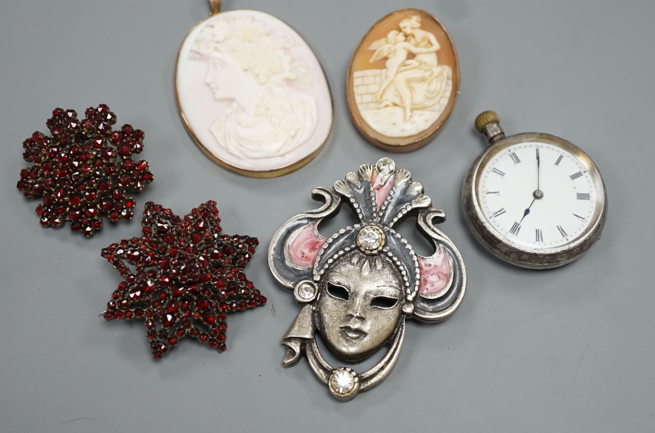 A yellow metal mounted cameo shell brooch and a similar pendant, two brooches, a white metal fob watch and one other brooch.